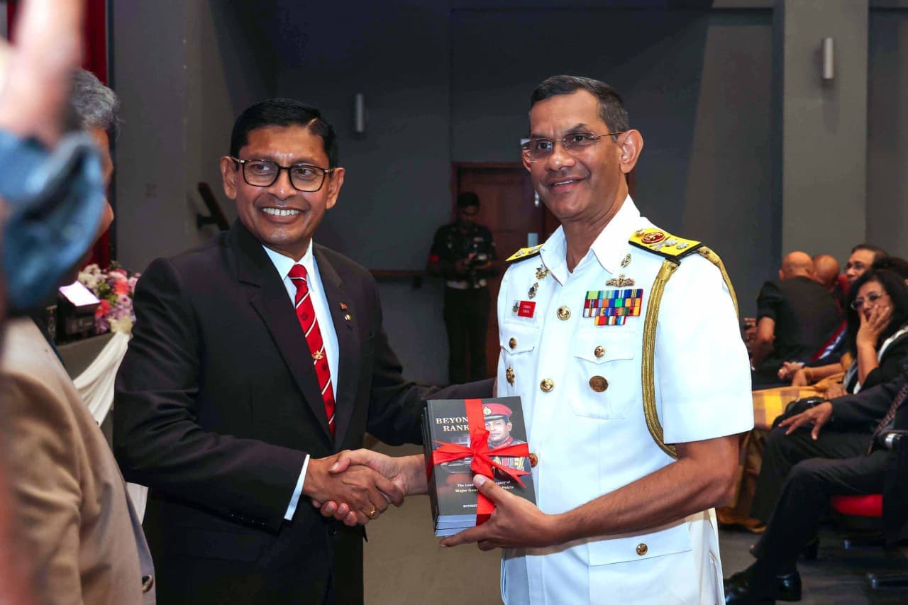 Major General (Retd) Milinda Peiris presenting a copy of Beyond Rank to Rear Admiral H. G. U. Dammika Kumara, Vice Chancellor of General Sir John Kotelawala Defence University and his successor at KDU.